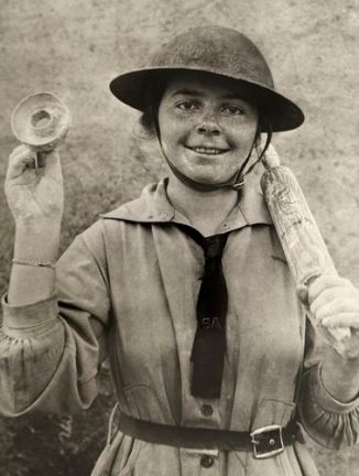 a-woman-in-the-salvation-army-holds-up-a-mold-for-cutting-donuts